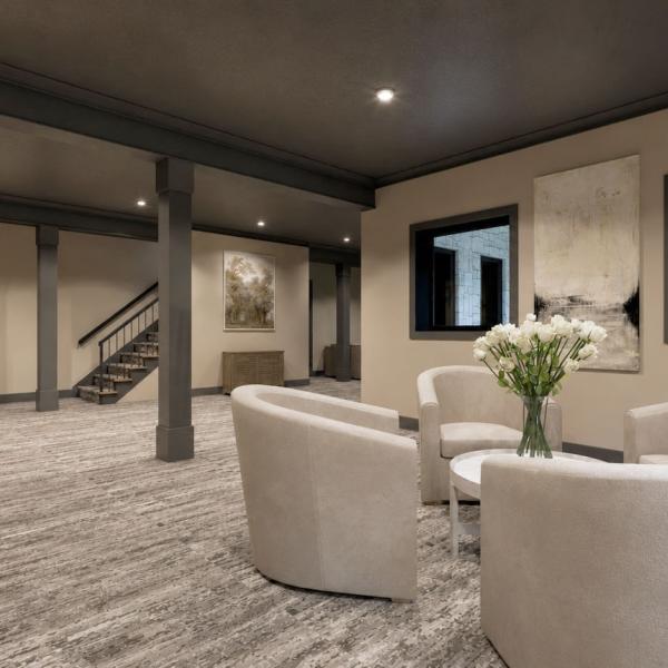 Finished walkout basement living room featuring dark charcoal ceiling, neutral sectional seating, built-in bookshelves, and sliding patio doors.