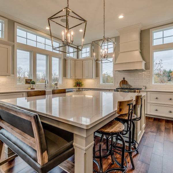 Kitchen with high ceilings, marble countertops and island, rustic yet modern features, and beautiful views.